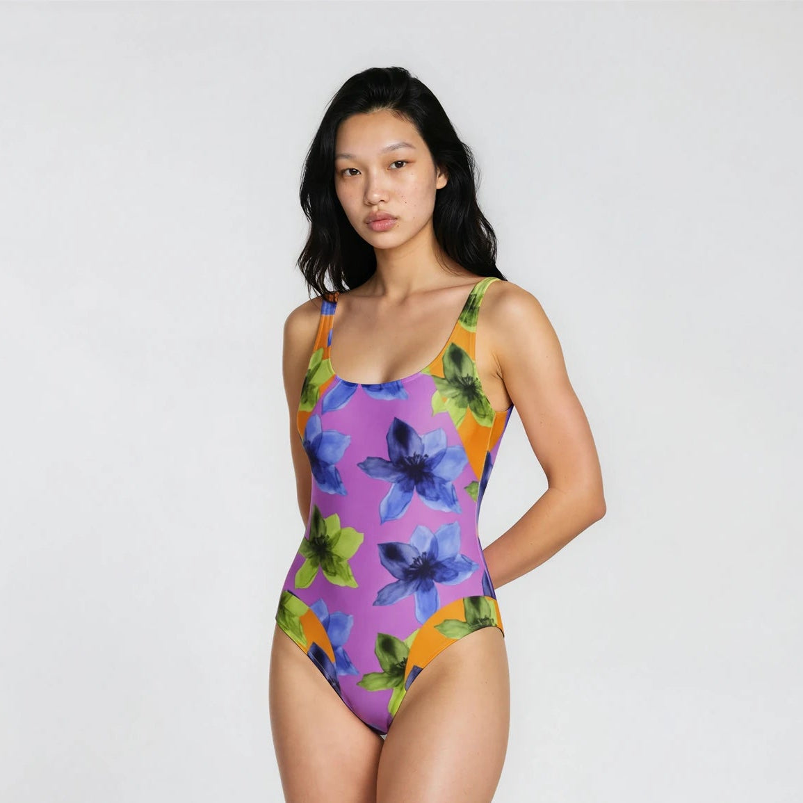 Woman wearing a colorful floral swimsuit on a white background