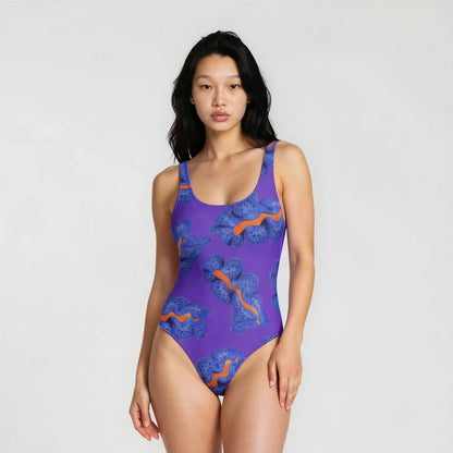 Woman wearing a purple swimsuit with orange patterns on a white background