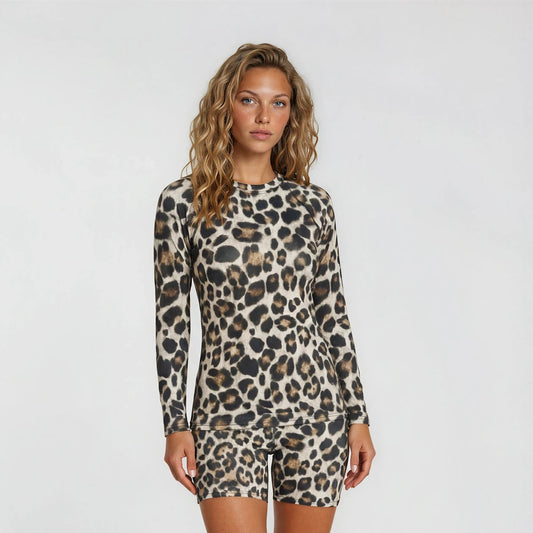 Woman wearing a leopard print long-sleeve romper on a white background
