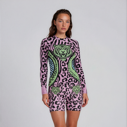 Person wearing a pink leopard print onesie with green accents on a white background