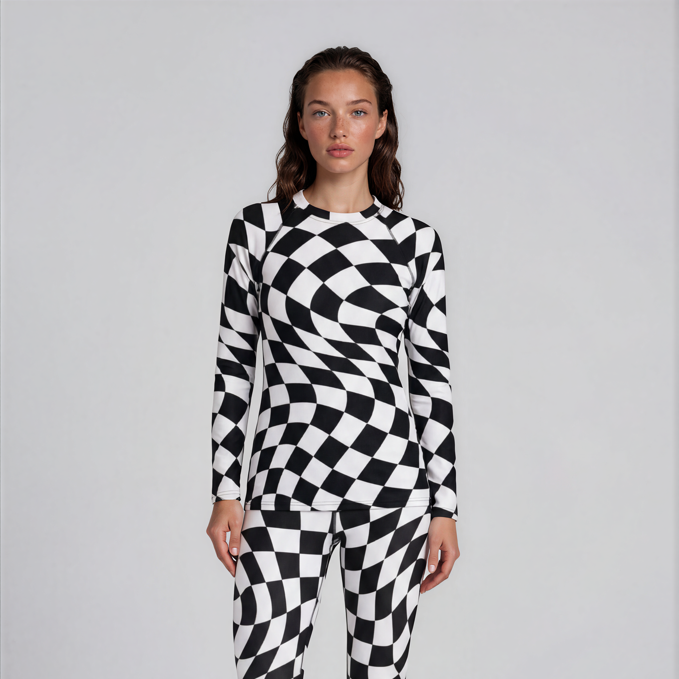 Person wearing a black and white checkered onesie on a plain background