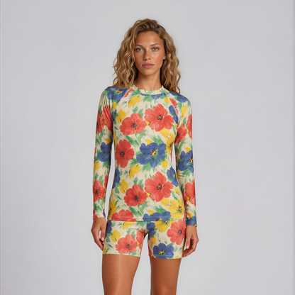 Woman wearing a colorful floral long-sleeve shirt and shorts on a white background