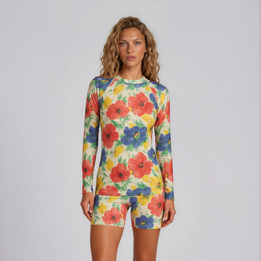 Woman wearing a colorful floral long-sleeve shirt and shorts on a white background